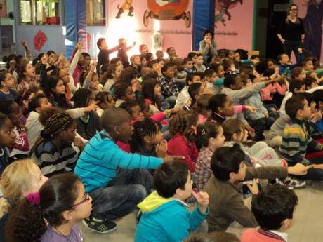 Un public de jeunes enfants qui participe et aide le magicien