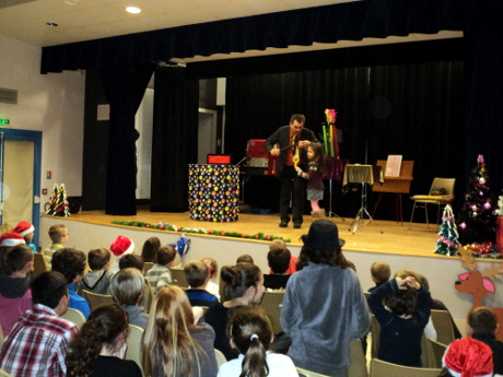 Un public attentif d'enfants et parents quand le magicien fait des tours de magie à la salle des fêtes de la chapelle-hermier