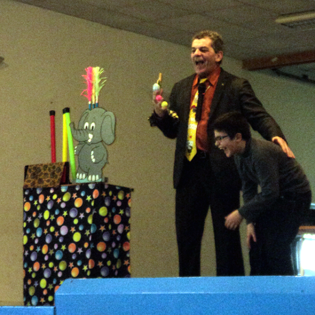 A Vénérand, l'enfant qui participe au spectacle du magicien est très content d'être sur la scène.